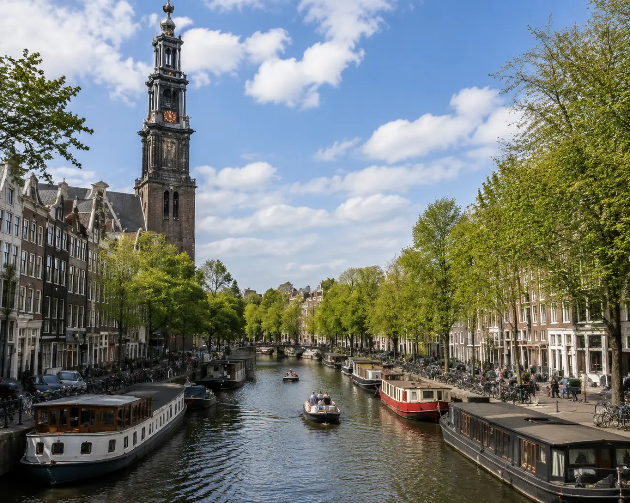 Prinsengracht kanalı boyunca yüzen evler ve arka planda Westerkerk çan kulesi, Jordaan mahallesi Amsterdam