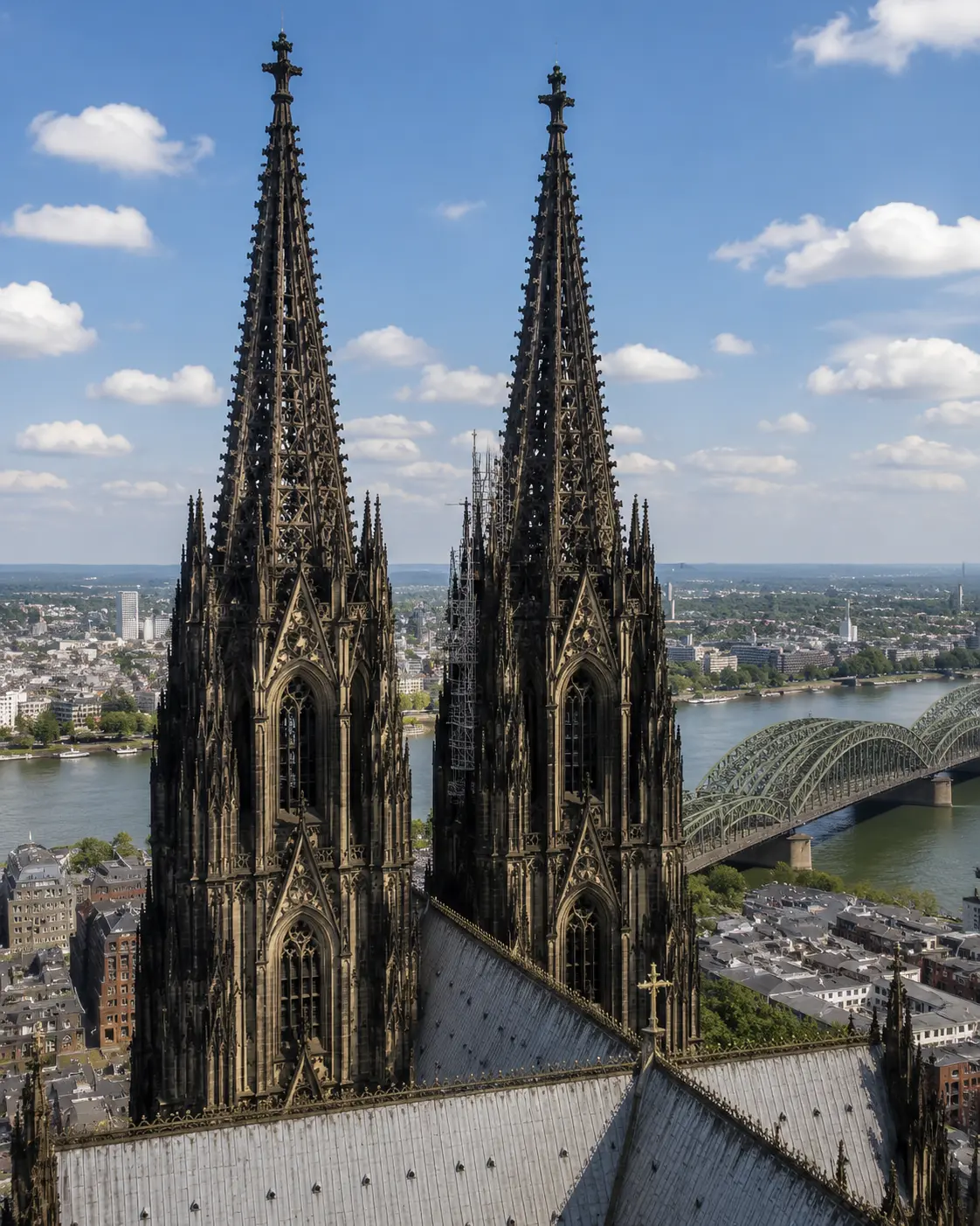 Köln Katedrali’nin ikiz gotik kuleleri yakın plan, arkada Hohenzollern Köprüsü